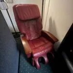 Burgundy leather reclining chair with wooden armrests in a clinic waiting area